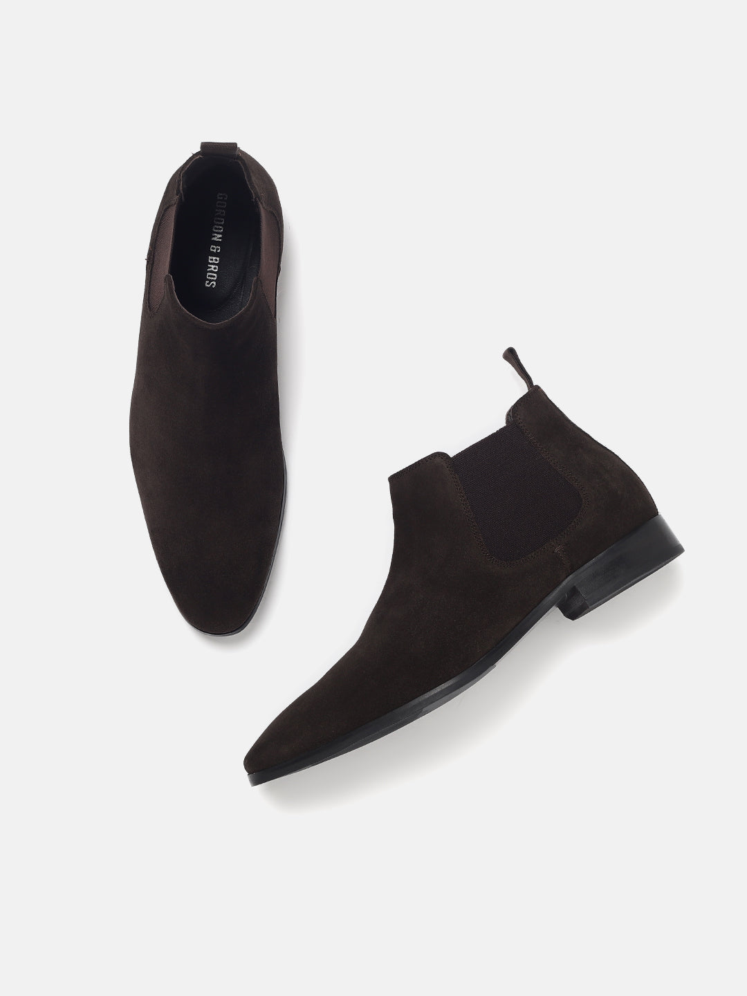 A pair of brown Chelsea boots with elasticated entry and a pull tab, featuring a leather inlay sole and a soft textile lining.