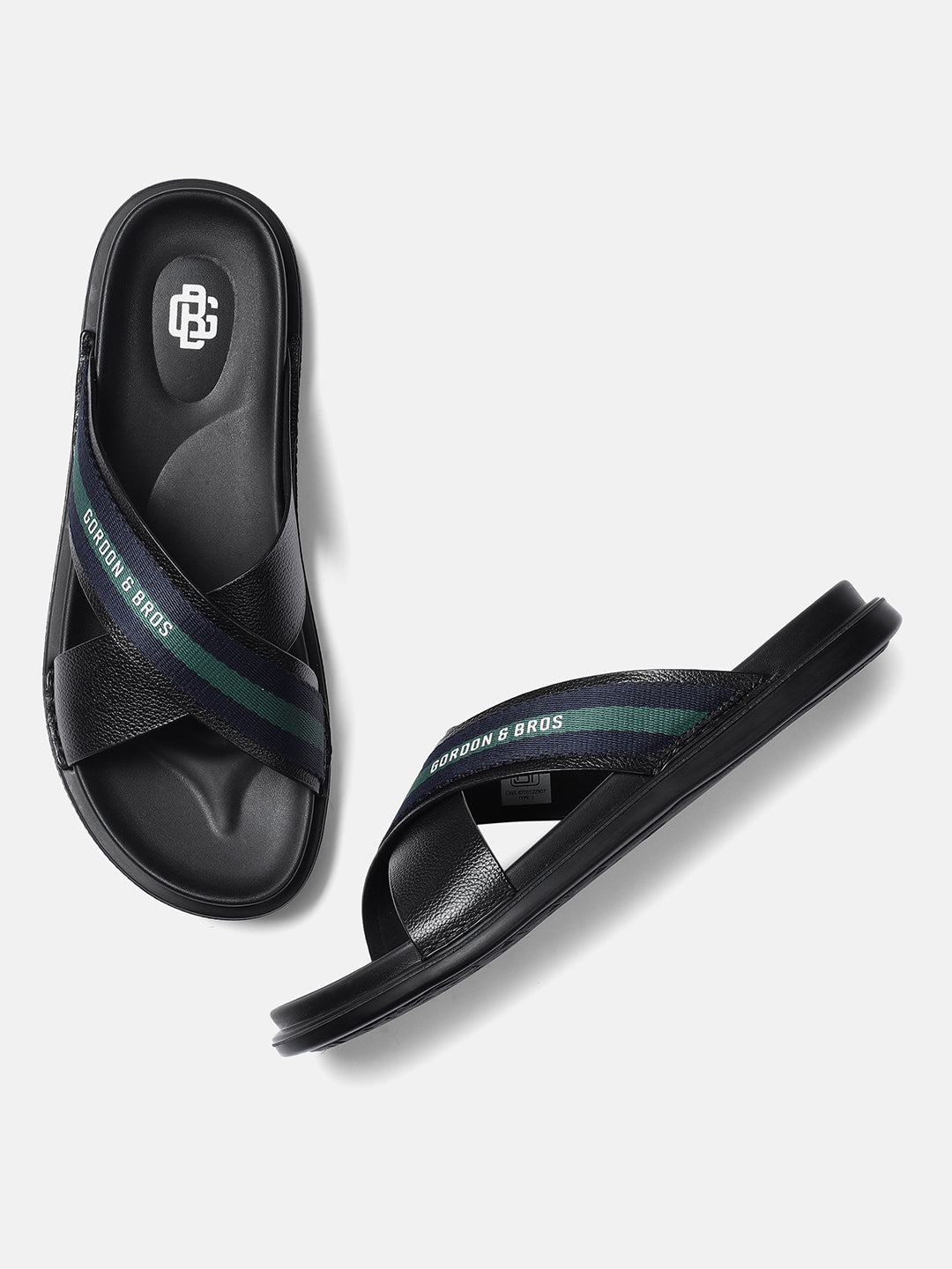 A pair of black leather men's sandals with green detailing on the straps.