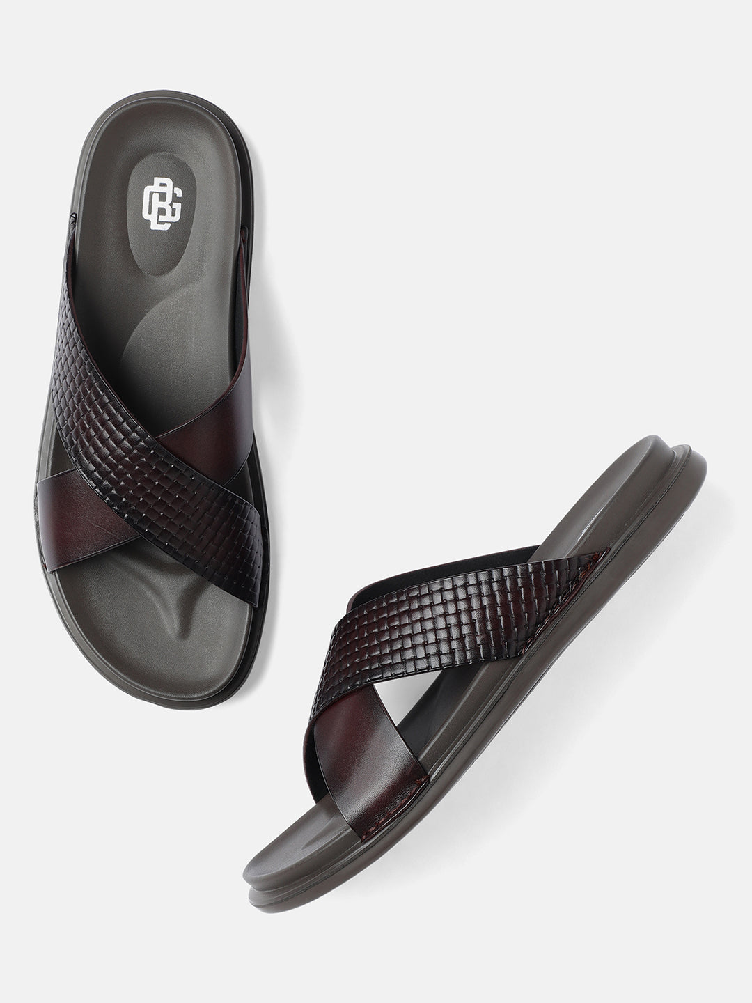 A pair of burgundy men's sandals with crossed leather straps.