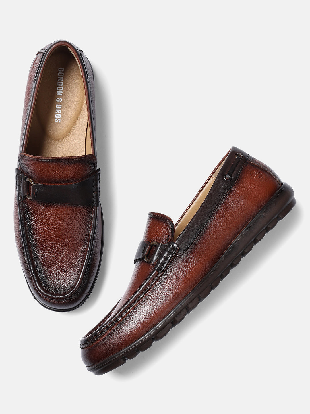 A pair of brown leather men's loafers with a wave pattern design.