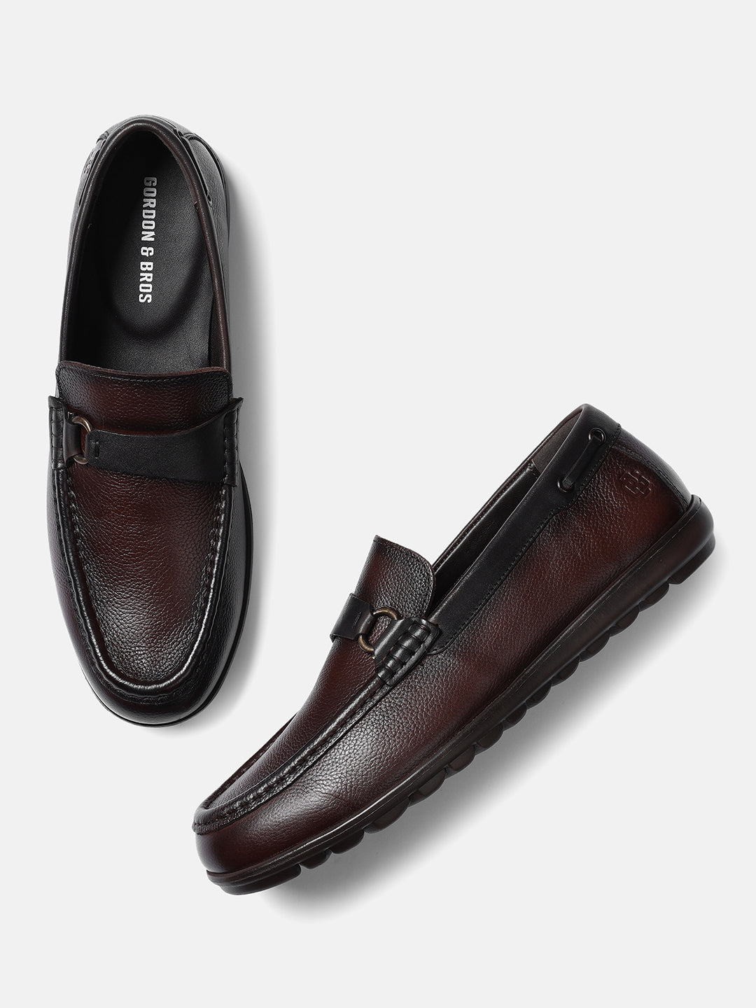 A pair of brown men's leather loafers with a buckle strap and perforated details.