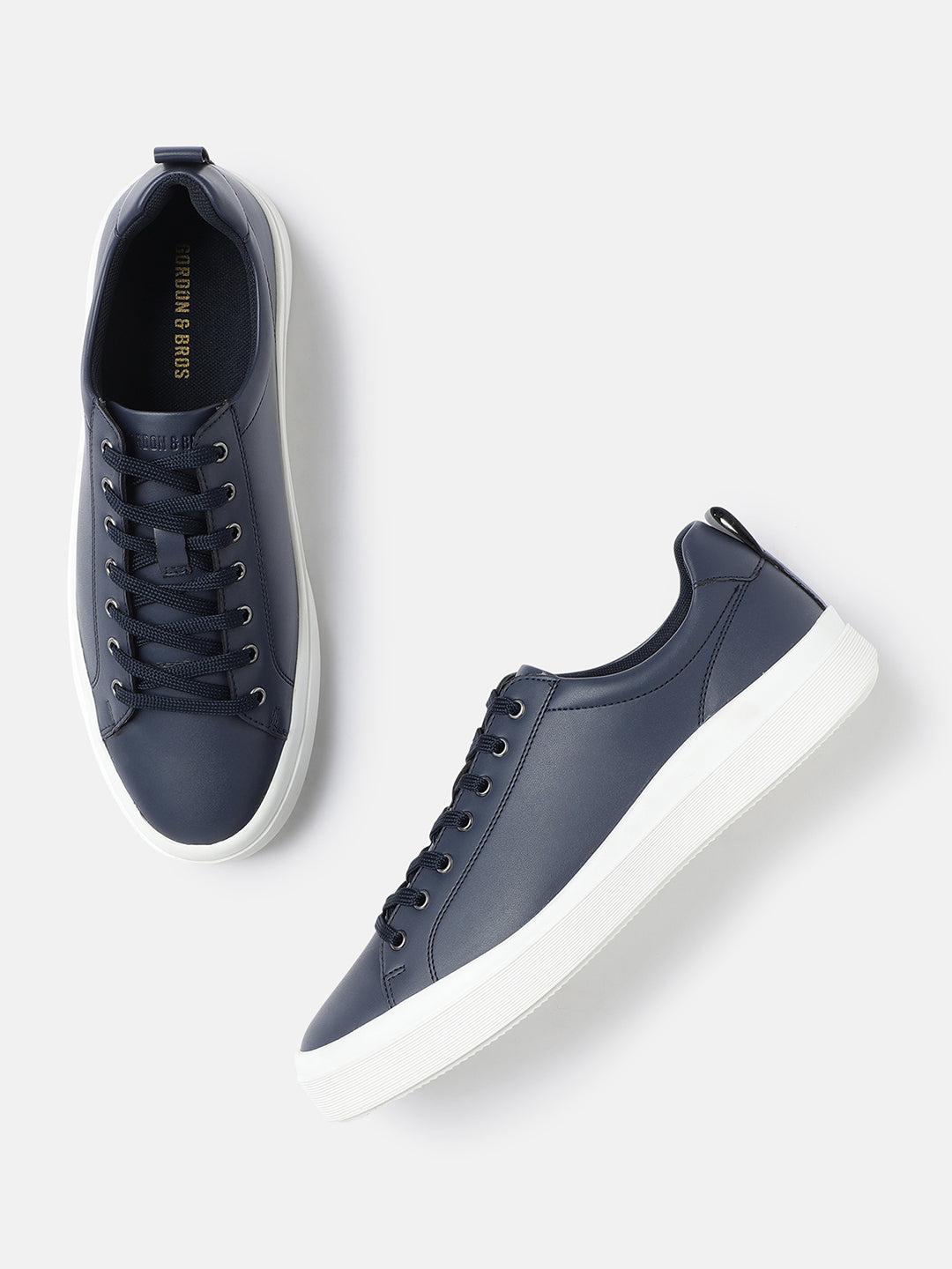 A pair of navy men's lace-up sneakers with a white sole.