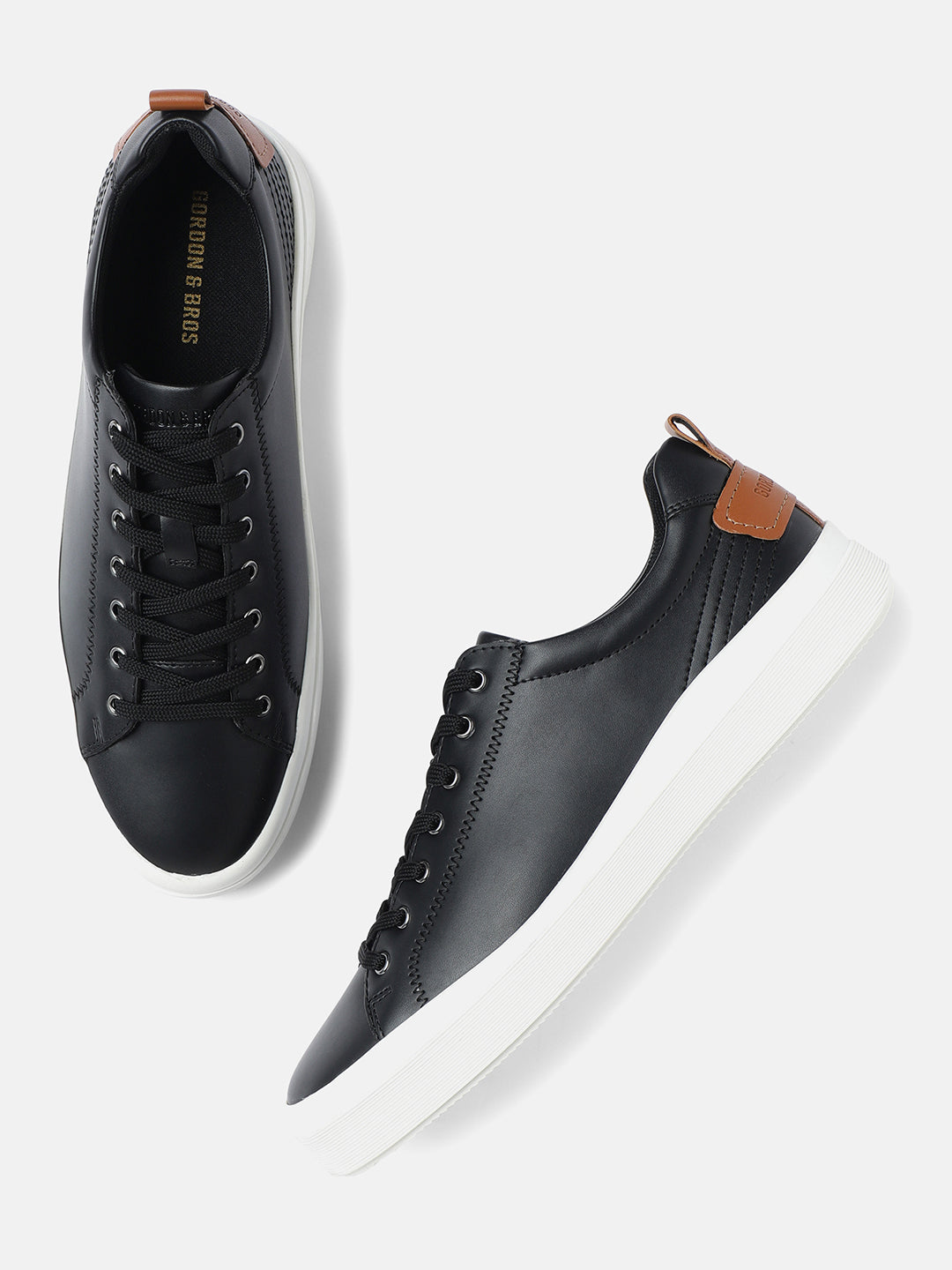 A pair of men's black and tan lace-up sneakers by GORDON & BROS, displayed against a white background.