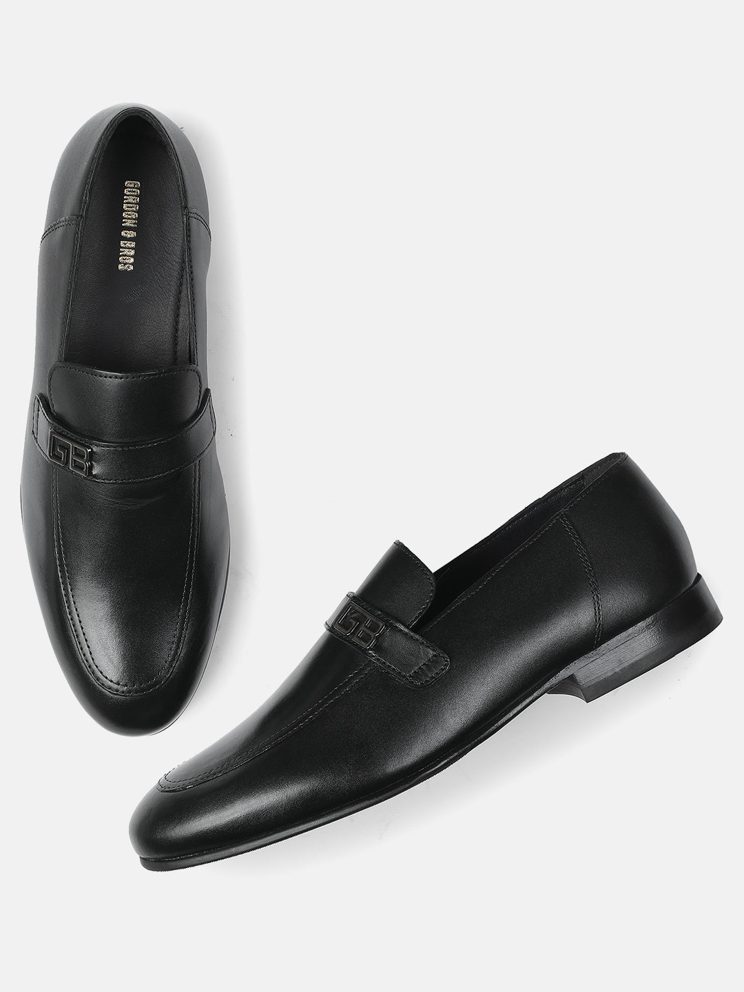 Pair of black leather loafers on a white background